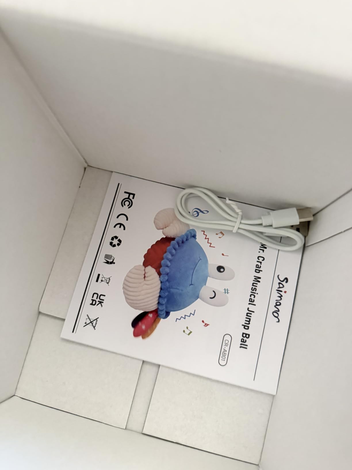 SAIMAND crab musical toy instruction booklet and USB charging cable inside the box
